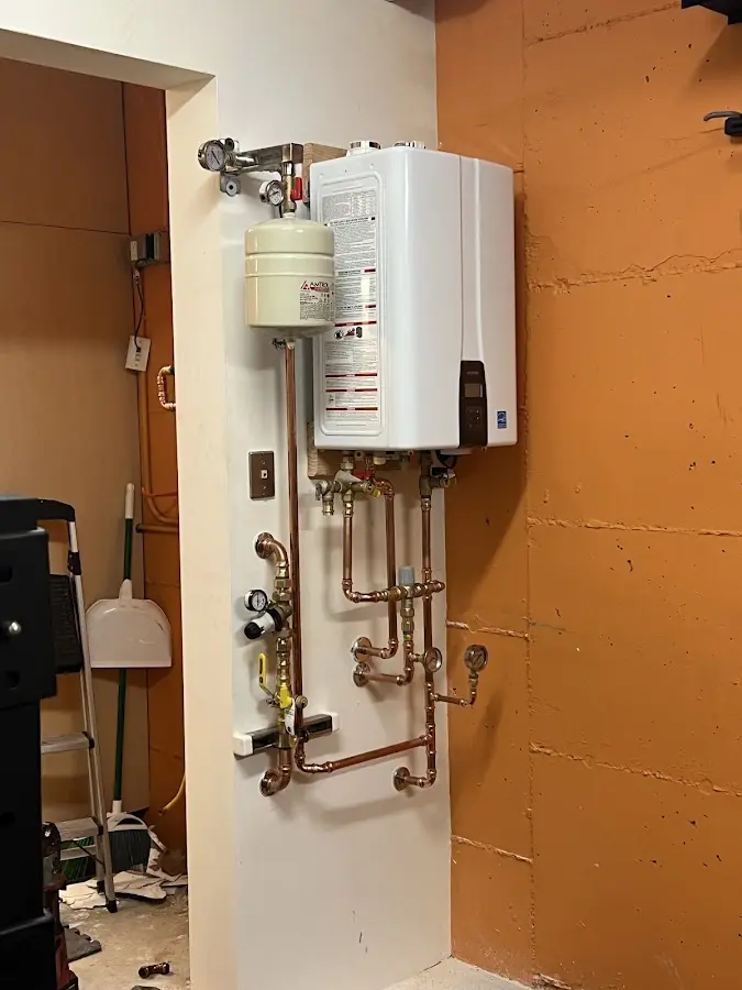 Plumbing technician inspecting water heater connections in New Fairfield